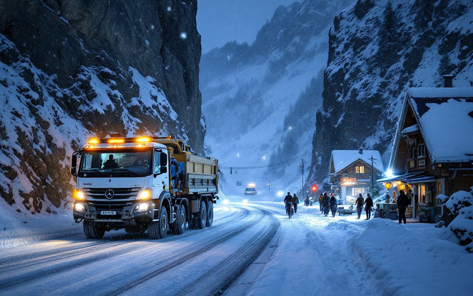 The Arlberg road at night in falling snow: a snow-clearing truck with its beacons on, an operator standing in the headlights, galleries and rock wall above
